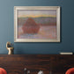 Impressionist haystack sunset scene in winter by Claude Monet in an ornate champagne frame displayed in a dark-toned interior setting.