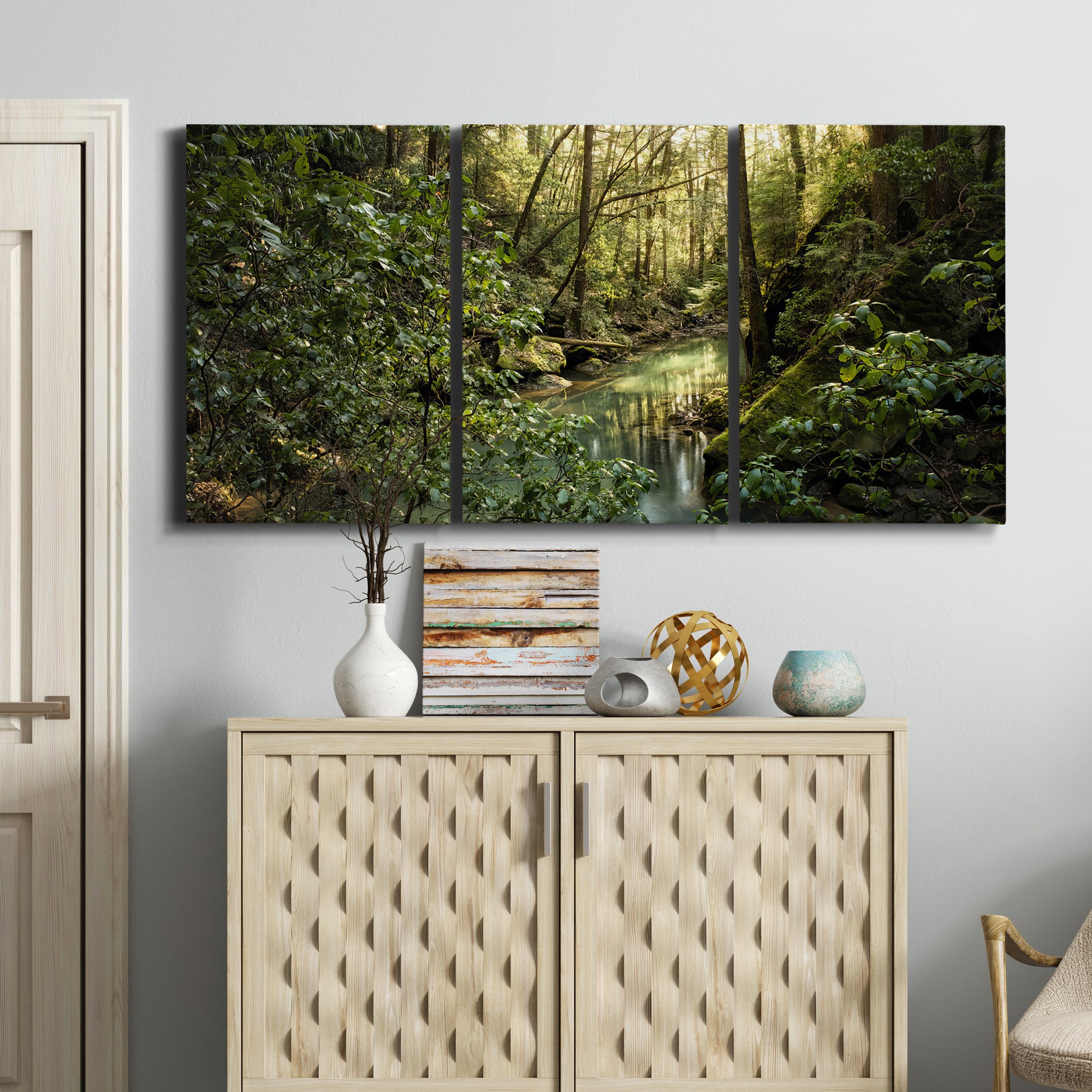 Three-panel canvas wall art featuring sun filtered woodland photograph, displayed above a cabinet in an entryway.