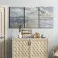 Three-panel canvas wall art featuring endless beach meeting ocean horizon, displayed above a cabinet in an entryway.
