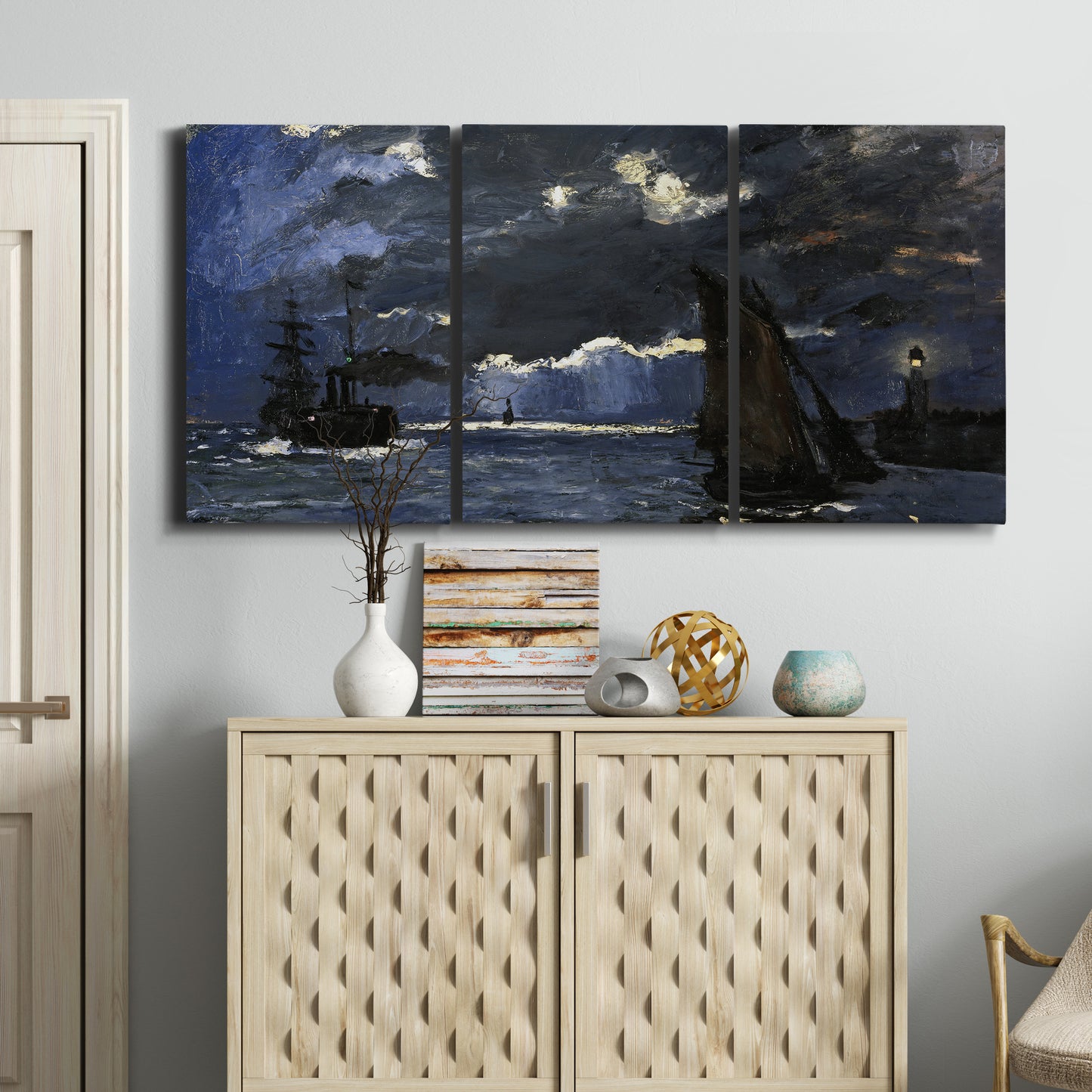 Three-panel canvas wall art featuring dark seascape under night sky, displayed above a cabinet in an entryway.