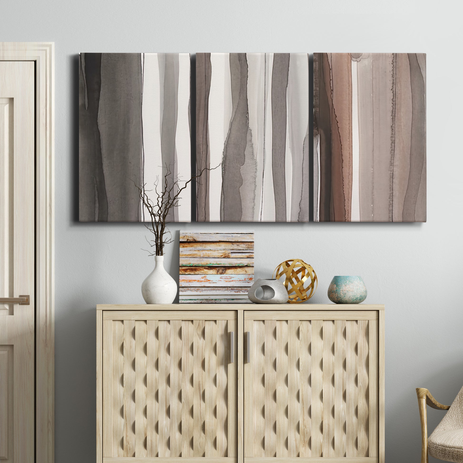 Three-panel canvas wall art featuring riverbank landscape with reflections, displayed above a cabinet in an entryway.