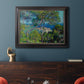 Impressionist Mediterranean coastal landscape by Claude Monet in an ornate black frame with gilded inner detail displayed in a dark-toned interior setting.