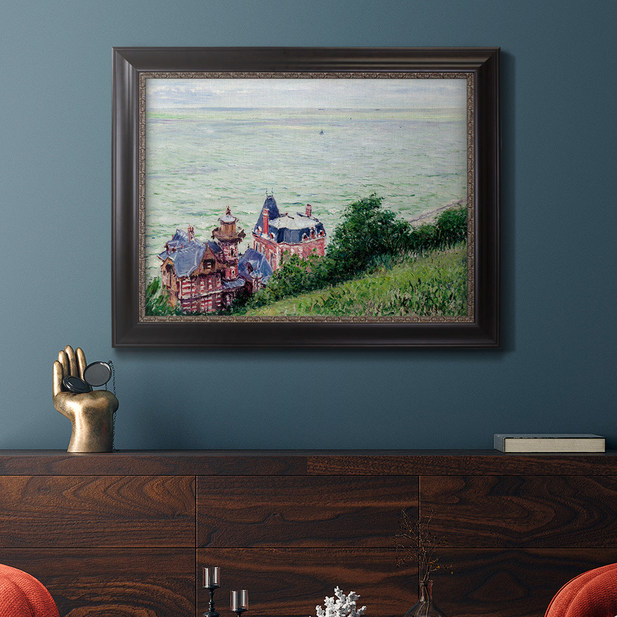 Impressionist coastal villas landscape by Gustave Caillebotte in an ornate black frame with gilded inner detail displayed in a dark-toned interior setting.