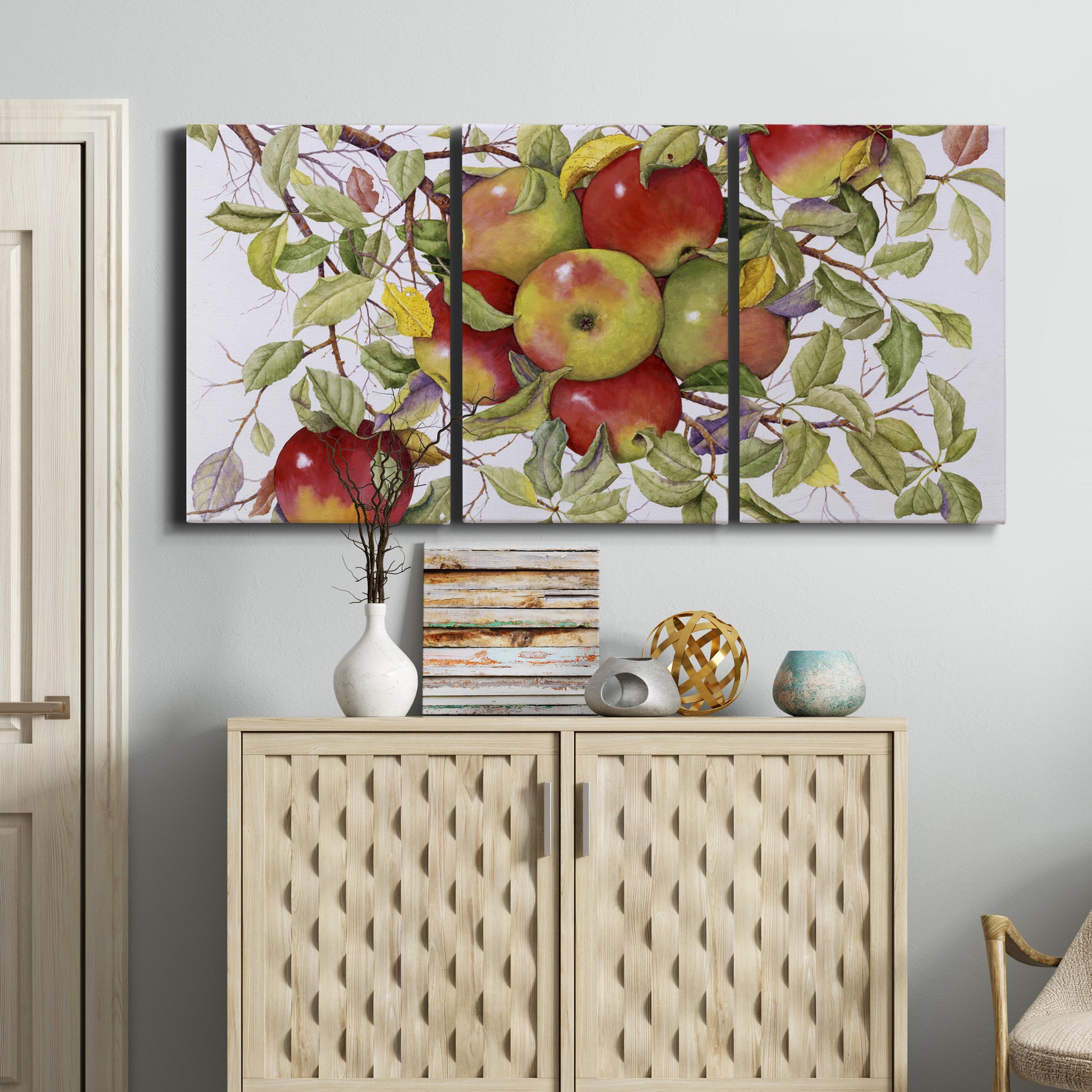 Three-panel canvas wall art featuring apples hanging from branch, displayed above a cabinet in an entryway.