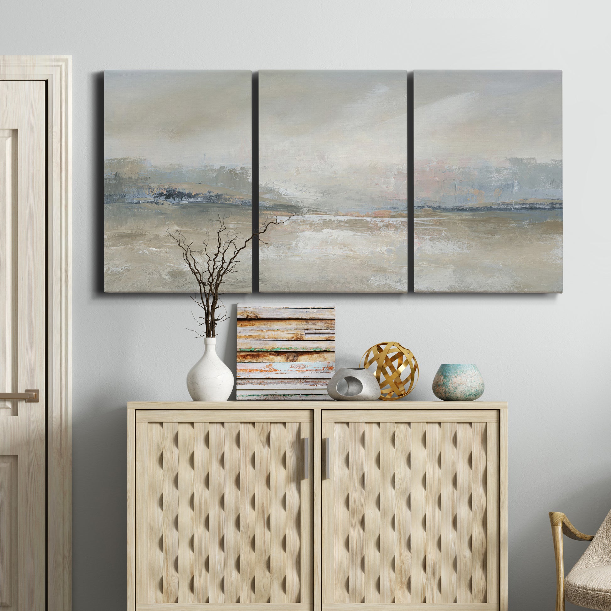 Three-panel canvas wall art featuring soft abstract horizon haze, displayed above a cabinet in an entryway.