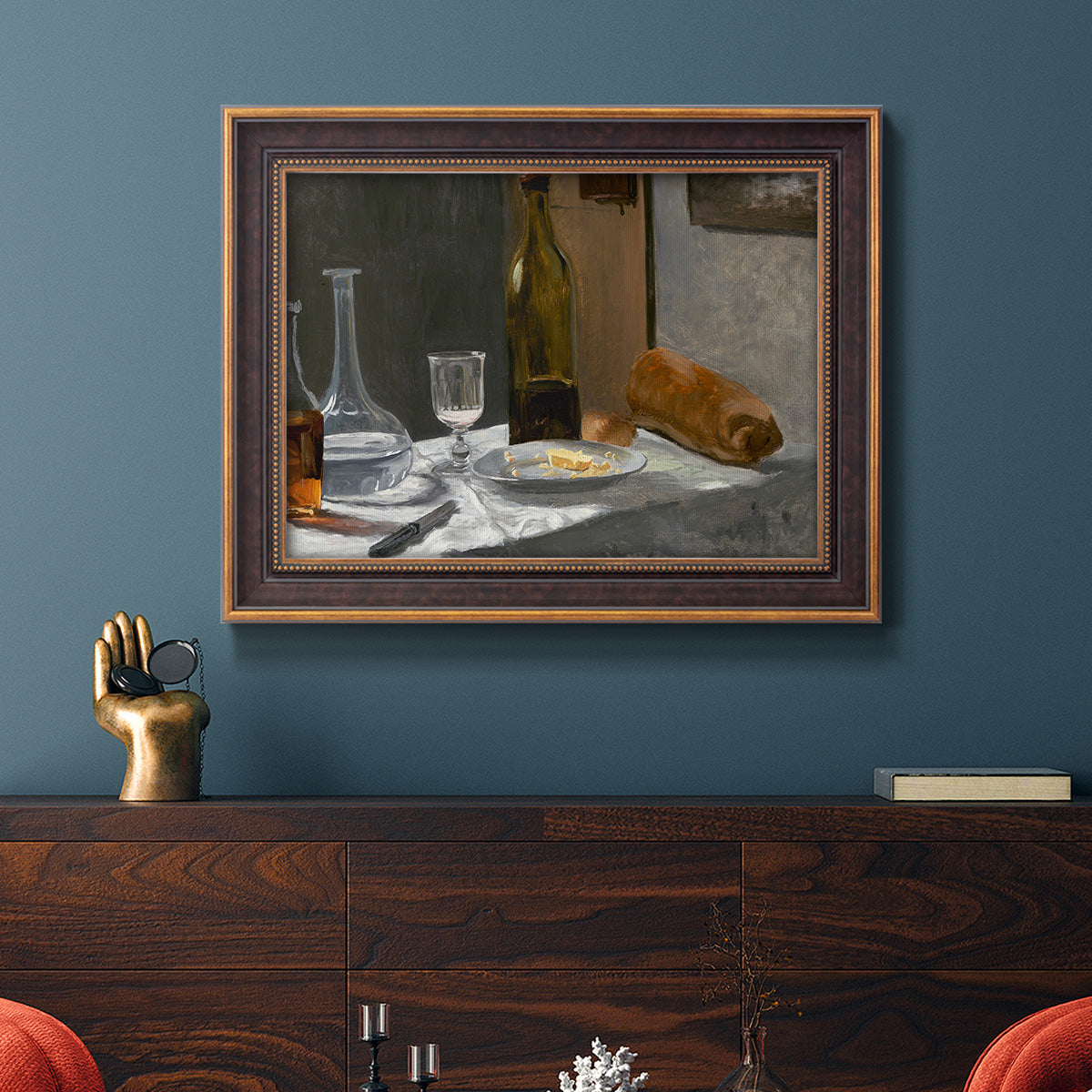 Impressionist still life with wine and bread by Claude Monet in an ornate bronzed mahogany wood frame displayed in a dark-toned interior setting.