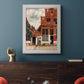 Realist city street scene by Johannes Vermeer in an ornate weathered white frame displayed in a dark-toned interior setting.