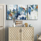 Three-panel canvas wall art featuring flowing abstract color movement, displayed above a cabinet in an entryway.