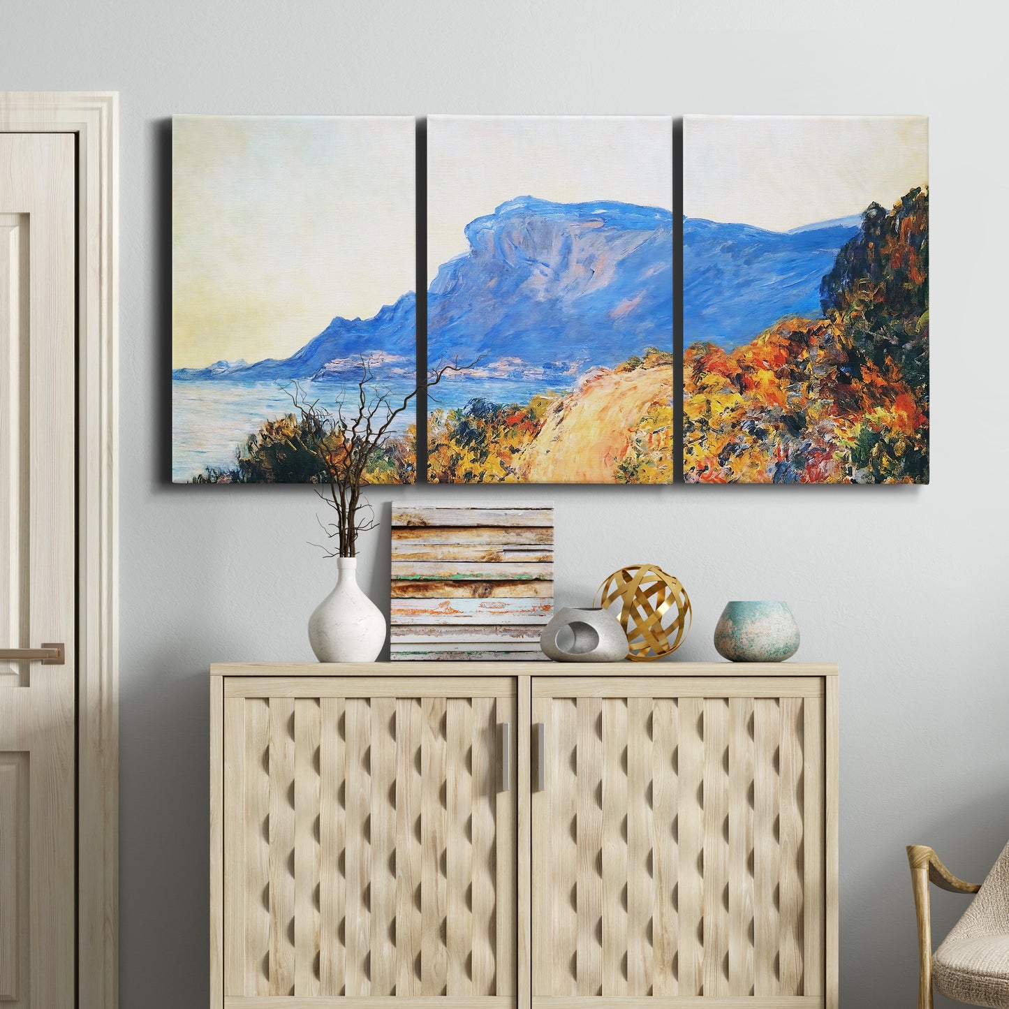 Three-panel canvas wall art featuring winding red road hillside, displayed above a cabinet in an entryway.