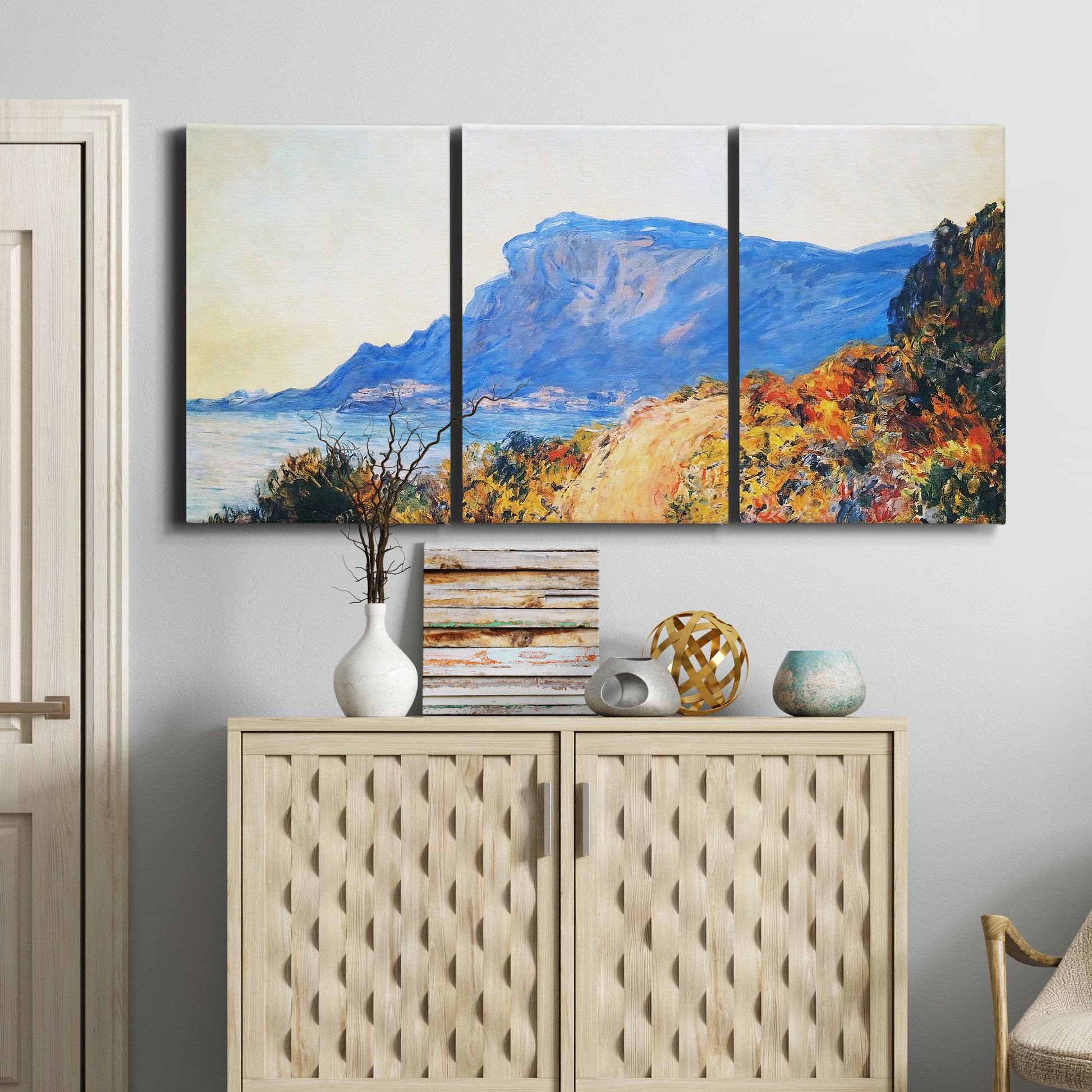 Three-panel canvas wall art featuring winding red road hillside, displayed above a cabinet in an entryway.
