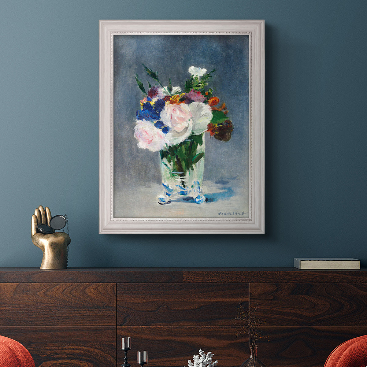 Impressionist floral still life painting by Claude Monet in an ornate weathered white frame displayed in a dark-toned interior setting.