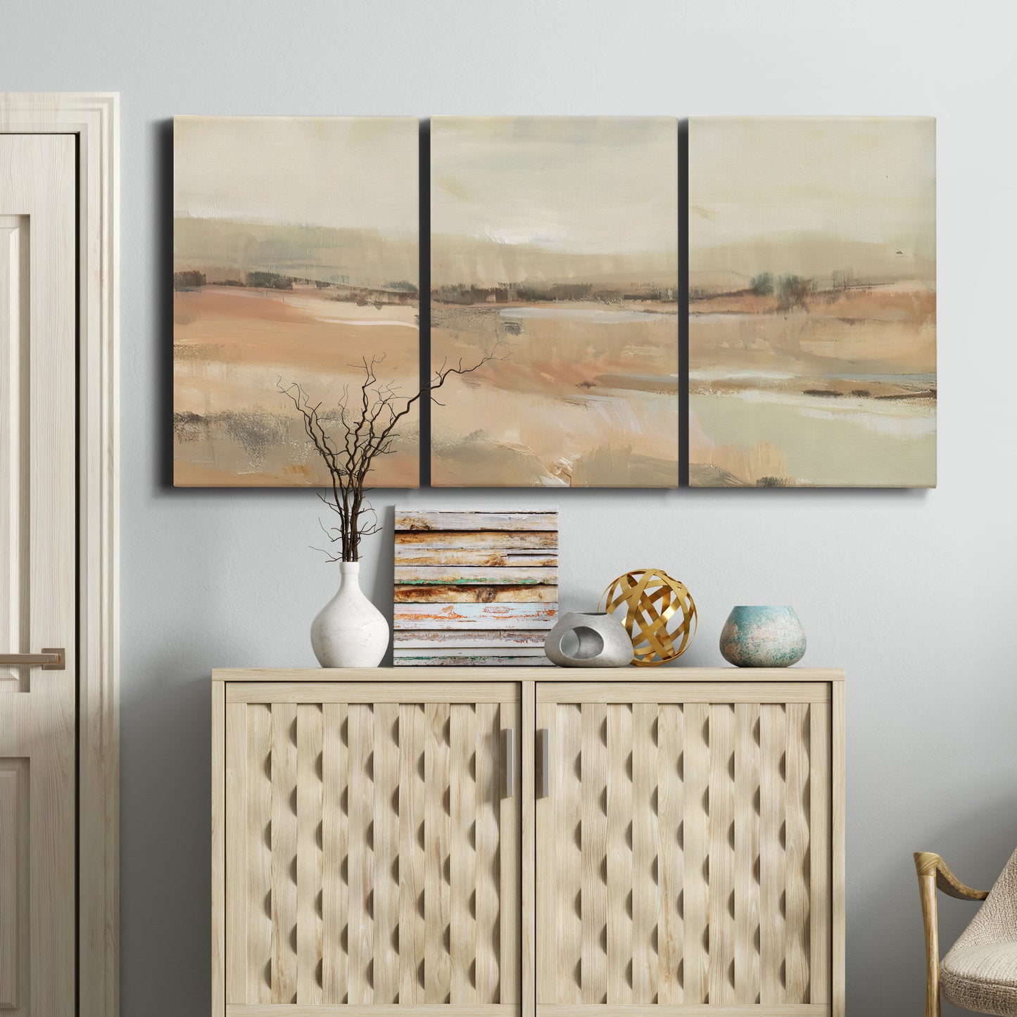 Three-panel canvas wall art featuring earth toned abstract landscape, displayed above a cabinet in an entryway.