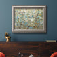 Impressionist flowering vine watercolor artwork in an ornate vintage silver frame displayed in a dark-toned interior setting.