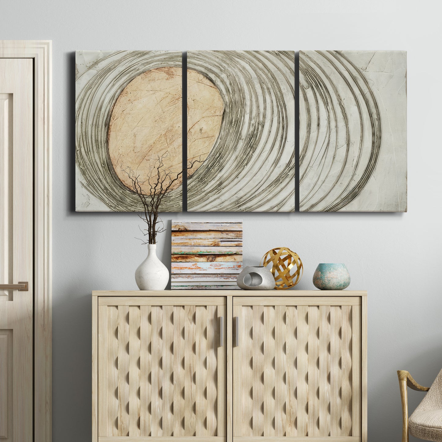 Three-panel canvas wall art featuring circular abstract energy forms, displayed above a cabinet in an entryway.
