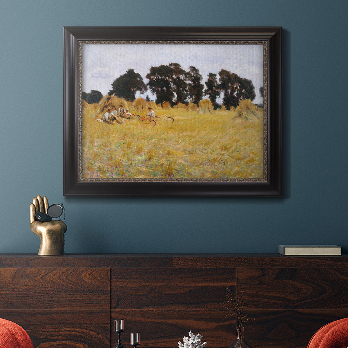 Impressionist rural harvest scene by John Singer Sargent in an ornate black frame with gilded inner detail displayed in a dark-toned interior setting.