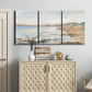 Three-panel canvas wall art featuring coastal shoreline landscape study, displayed above a cabinet in an entryway.