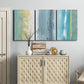 Three-panel canvas wall art featuring abstract coastal beach textures, displayed above a cabinet in an entryway.