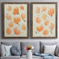 Set of two walnut barnwood framed canvas prints depicting paired airy watercolor floral paintings with soft petals, thin black stems, and warm cream backgrounds above a sofa in a contemporary living room.