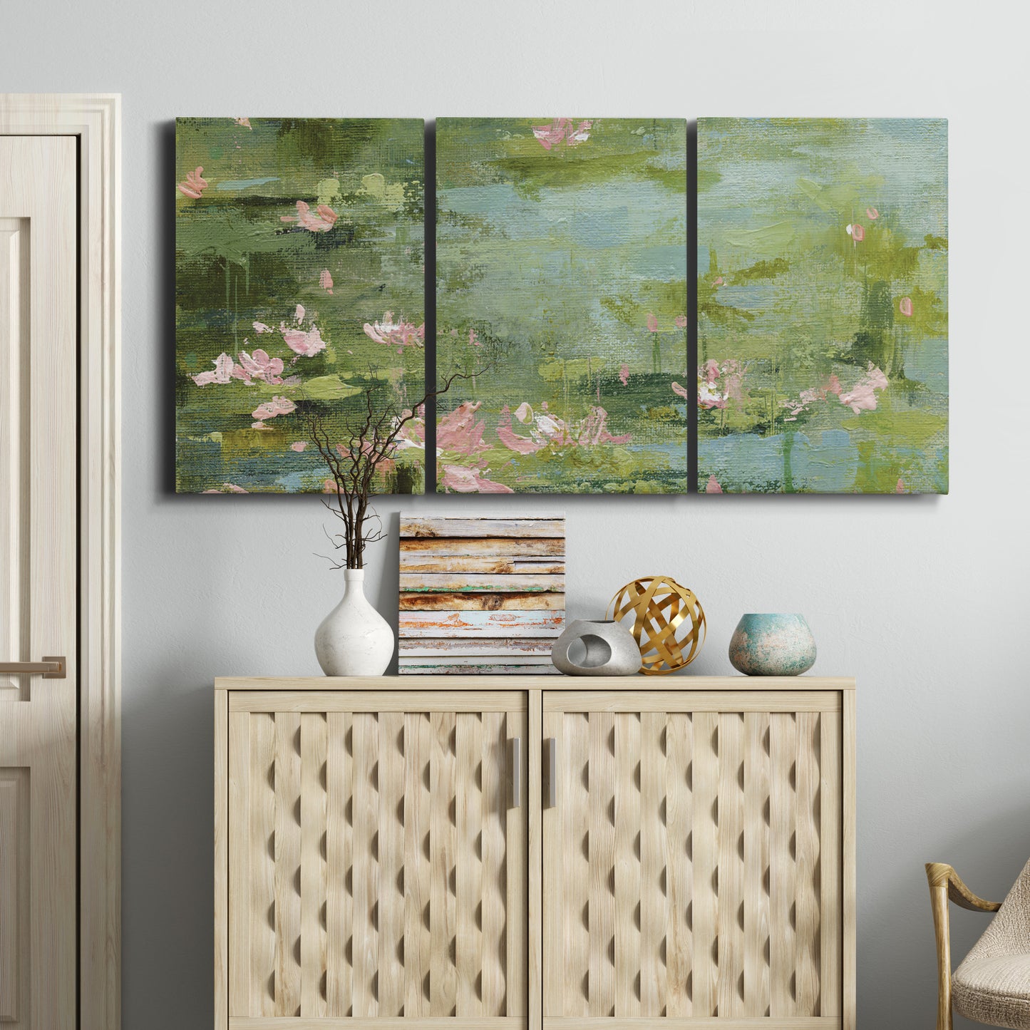 Three-panel canvas wall art featuring muted water lily pond, displayed above a cabinet in an entryway.