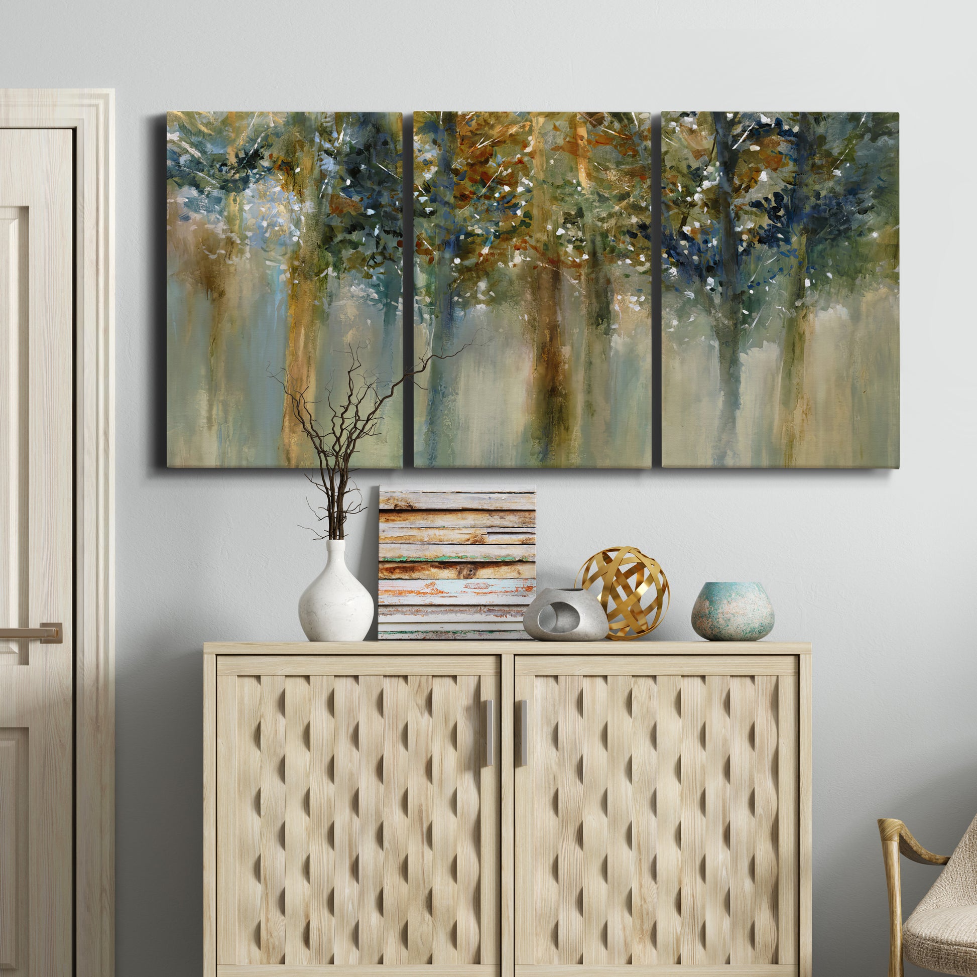 Three-panel canvas wall art featuring earth toned abstract leaf textures, displayed above a cabinet in an entryway.