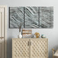 Three-panel canvas wall art featuring coastal shoreline with gentle surf, displayed above a cabinet in an entryway.