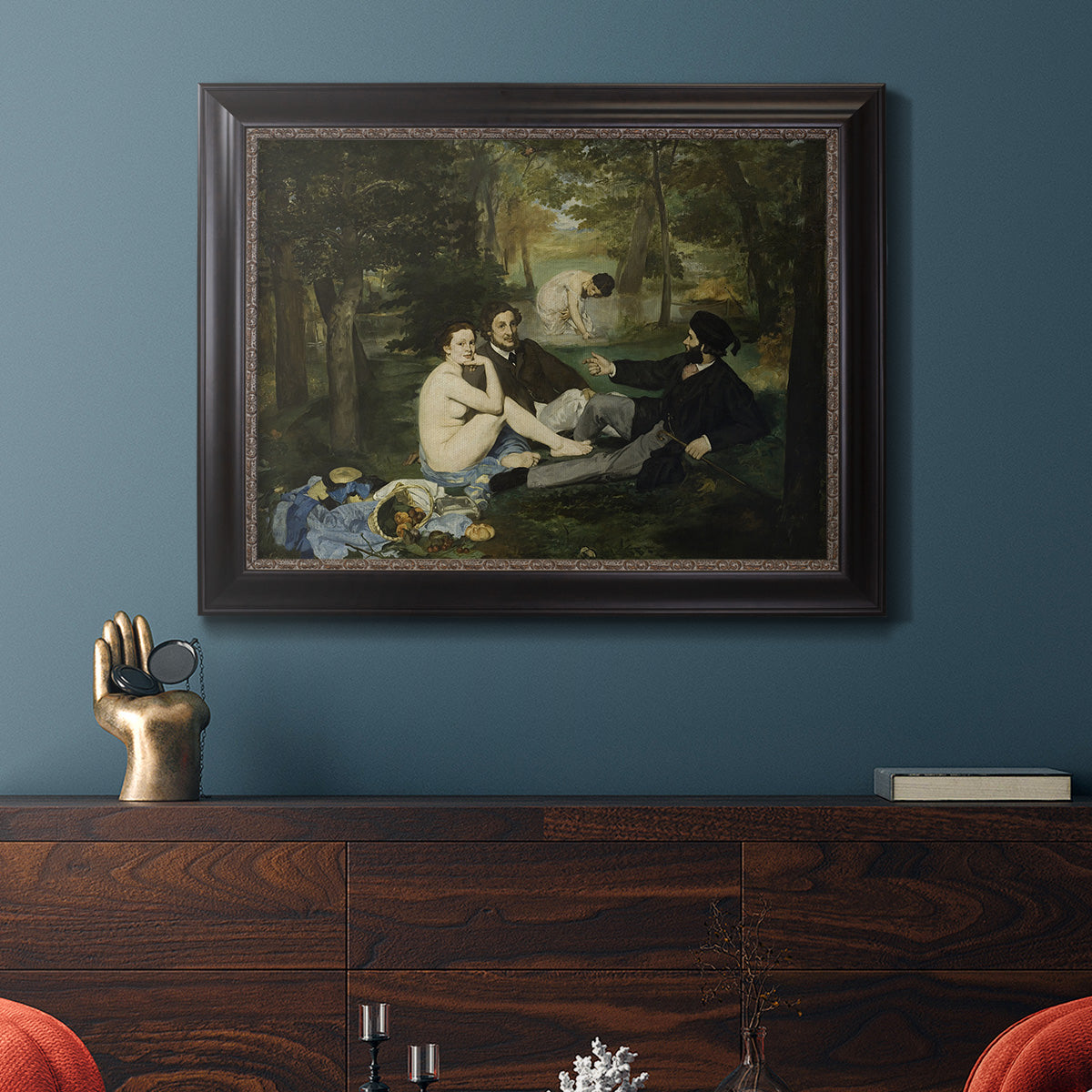 Groundbreaking impressionist picnic scene by Édouard Manet in an ornate black frame with gilded inner detail displayed in a dark-toned interior setting.