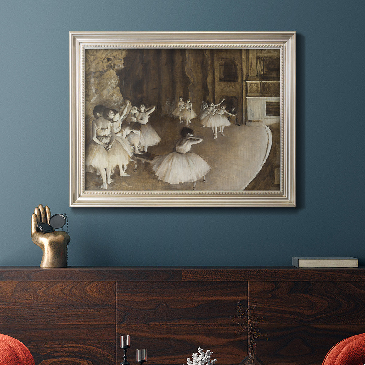 Impressionist ballet rehearsal scene by Edgar Degas in an ornate champagne frame displayed in a dark-toned interior setting.