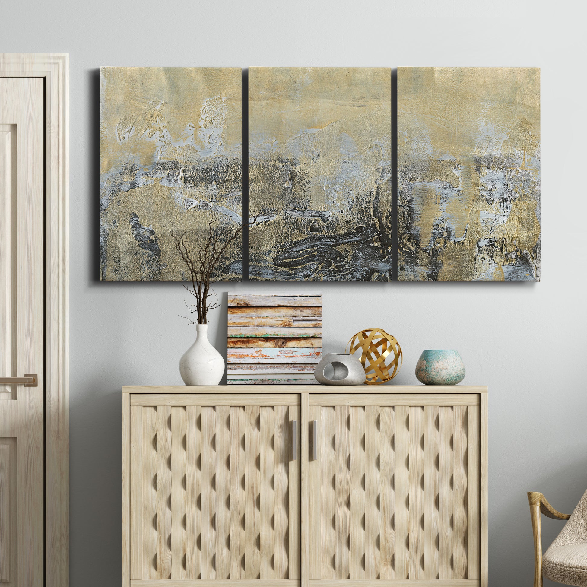 Three-panel canvas wall art featuring gold toned abstract horizon, displayed above a cabinet in an entryway.