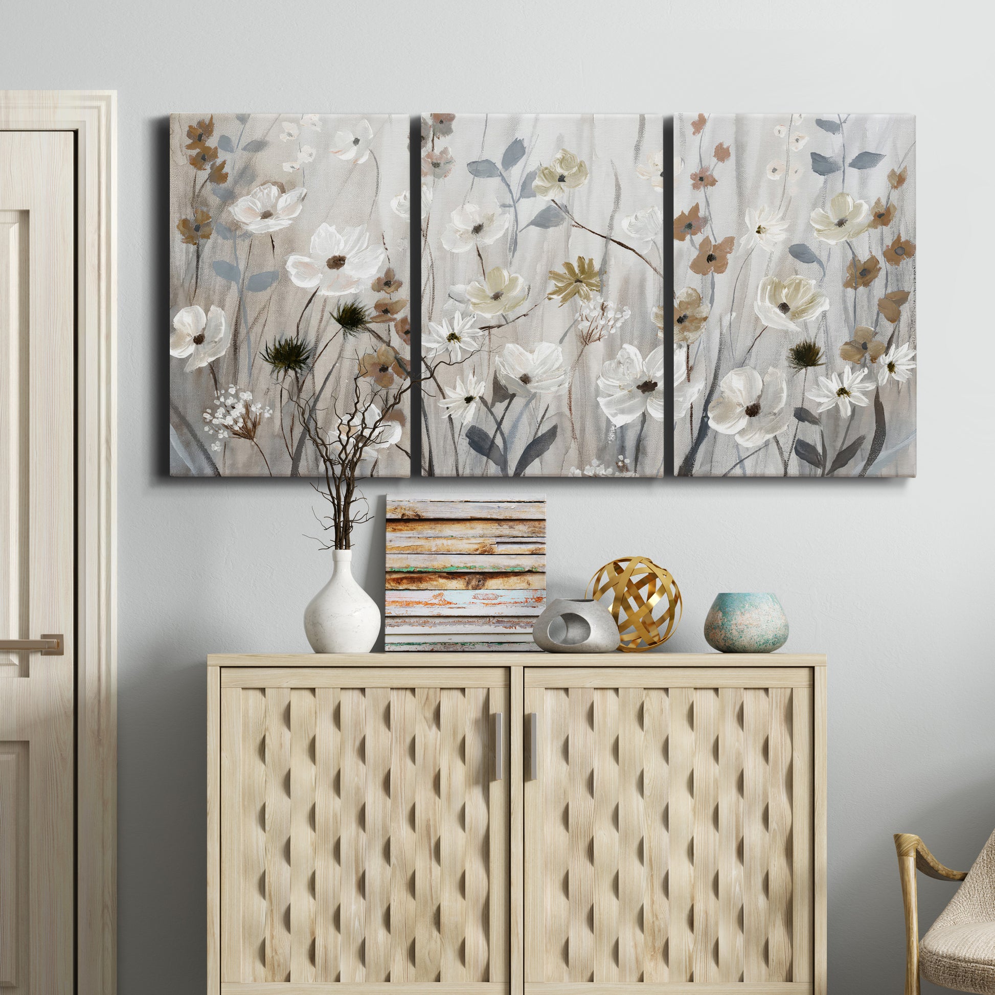 Three-panel canvas wall art featuring misty wildflower meadow landscape, displayed above a cabinet in an entryway.
