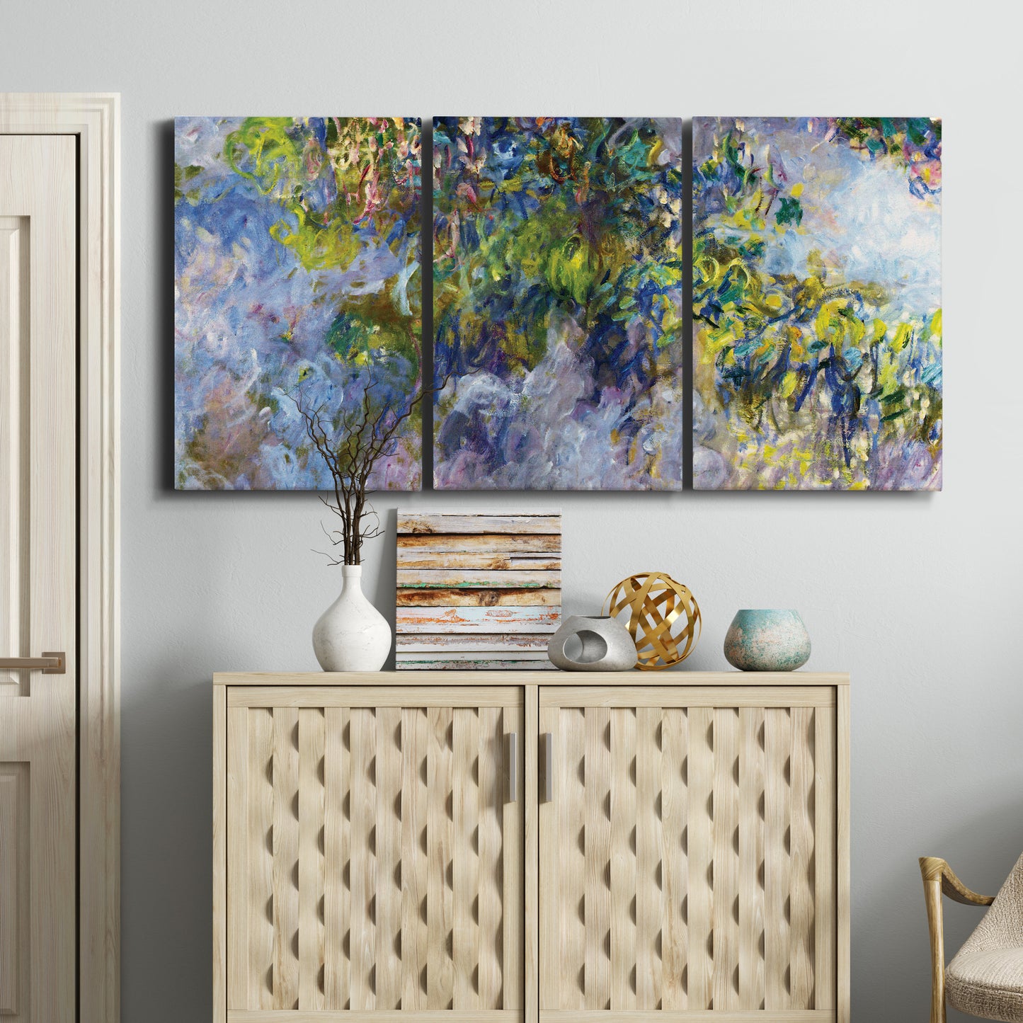 Three-panel canvas wall art featuring cascading purple wisteria blooms, displayed above a cabinet in an entryway.