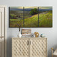 Three-panel canvas wall art featuring winding path through rolling hills, displayed above a cabinet in an entryway.