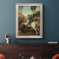 Religious painting of Saint George slaying the dragon by Raphael in an ornate champagne frame displayed in a dark-toned interior setting.