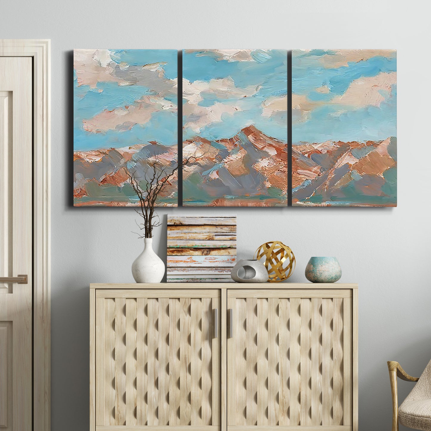 Three-panel canvas wall art featuring soft pastel western hills landscape, displayed above a cabinet in an entryway.