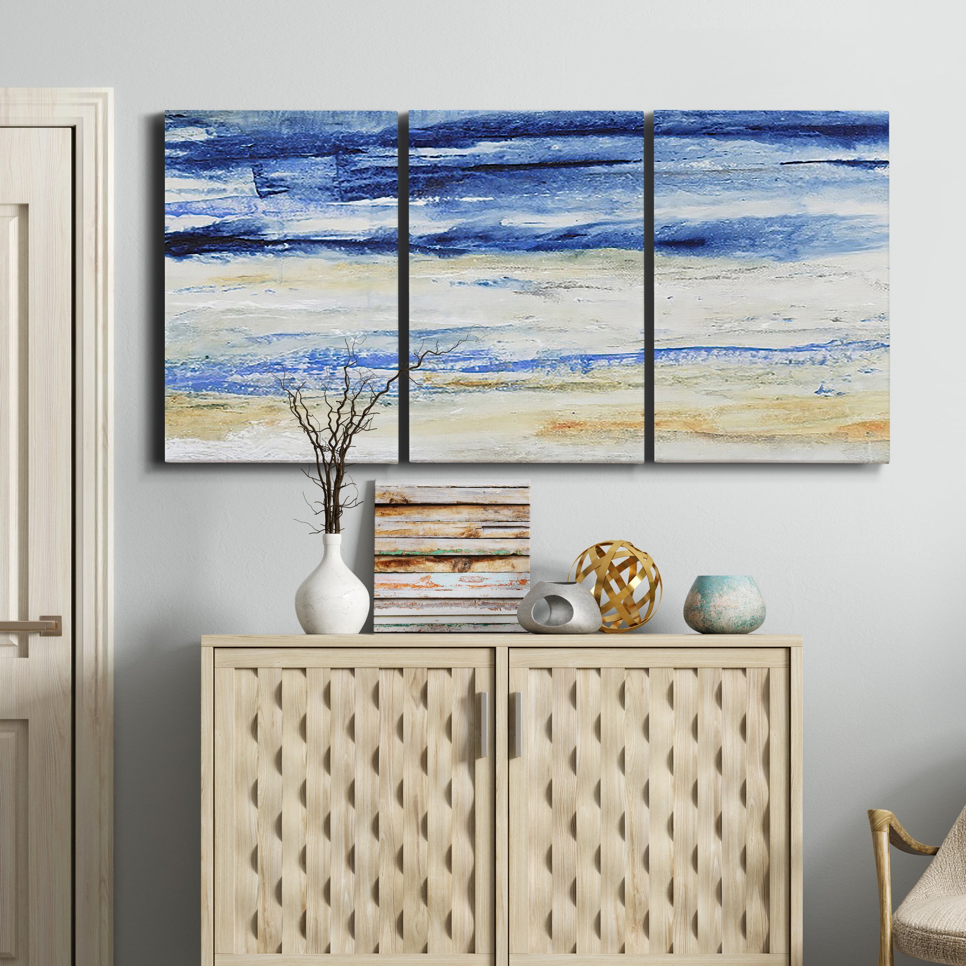 Three-panel canvas wall art featuring turbulent abstract ocean wave motion, displayed above a cabinet in an entryway.