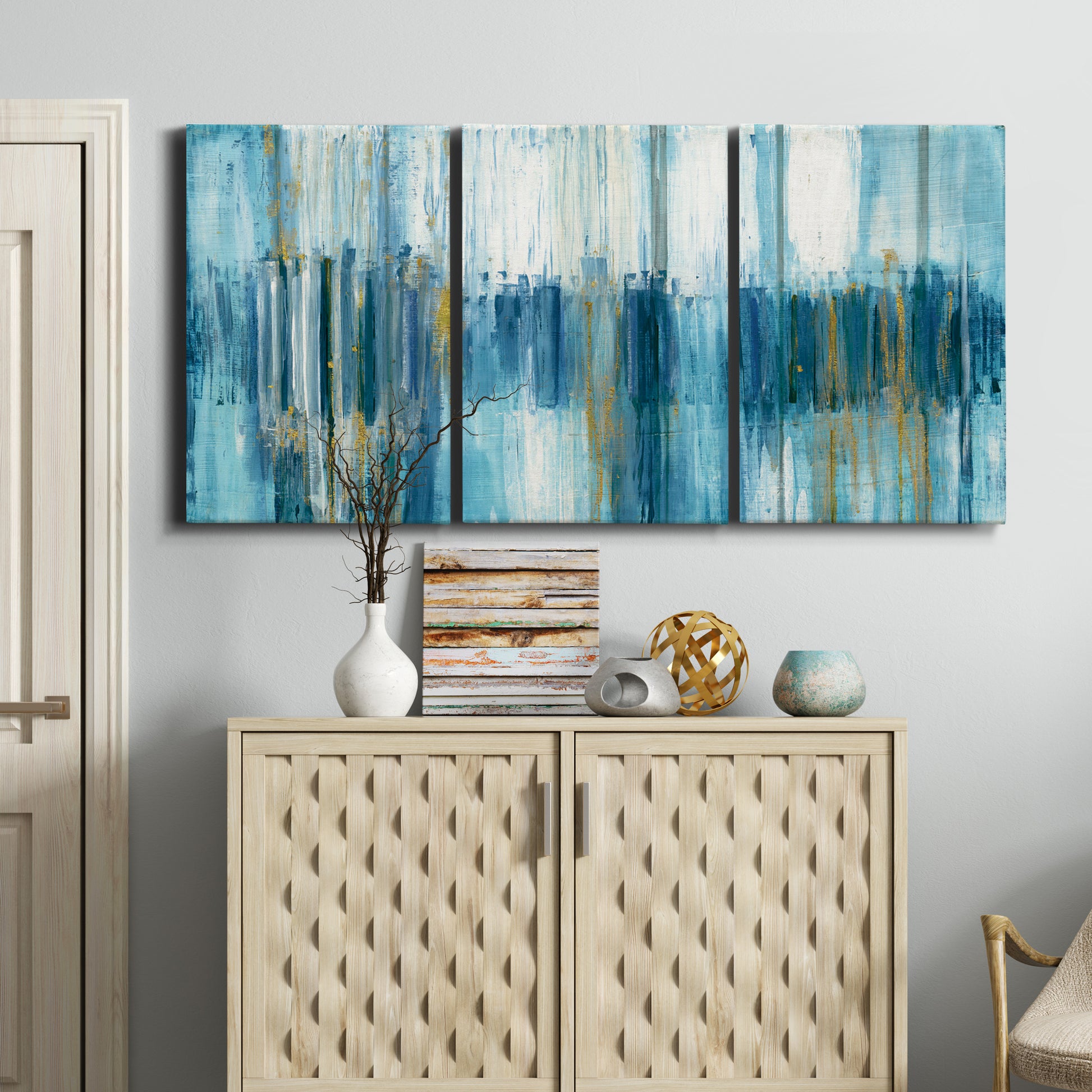 Three-panel canvas wall art featuring layered abstract earth tones, displayed above a cabinet in an entryway.