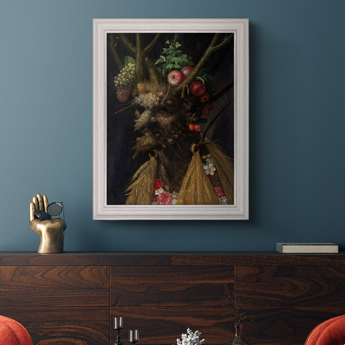 Surreal allegorical portrait representing the four seasons by Giuseppe Arcimboldo in an ornate weathered white frame displayed in a dark-toned interior setting.
