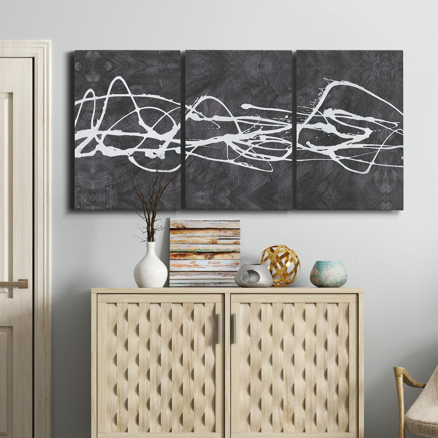 Three-panel canvas wall art featuring minimal abstract frequency lines, displayed above a cabinet in an entryway.