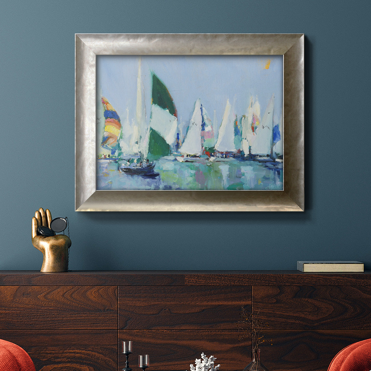 Coastal harbor watercolor painting in an ornate mottled silver frame displayed in a dark-toned interior setting.