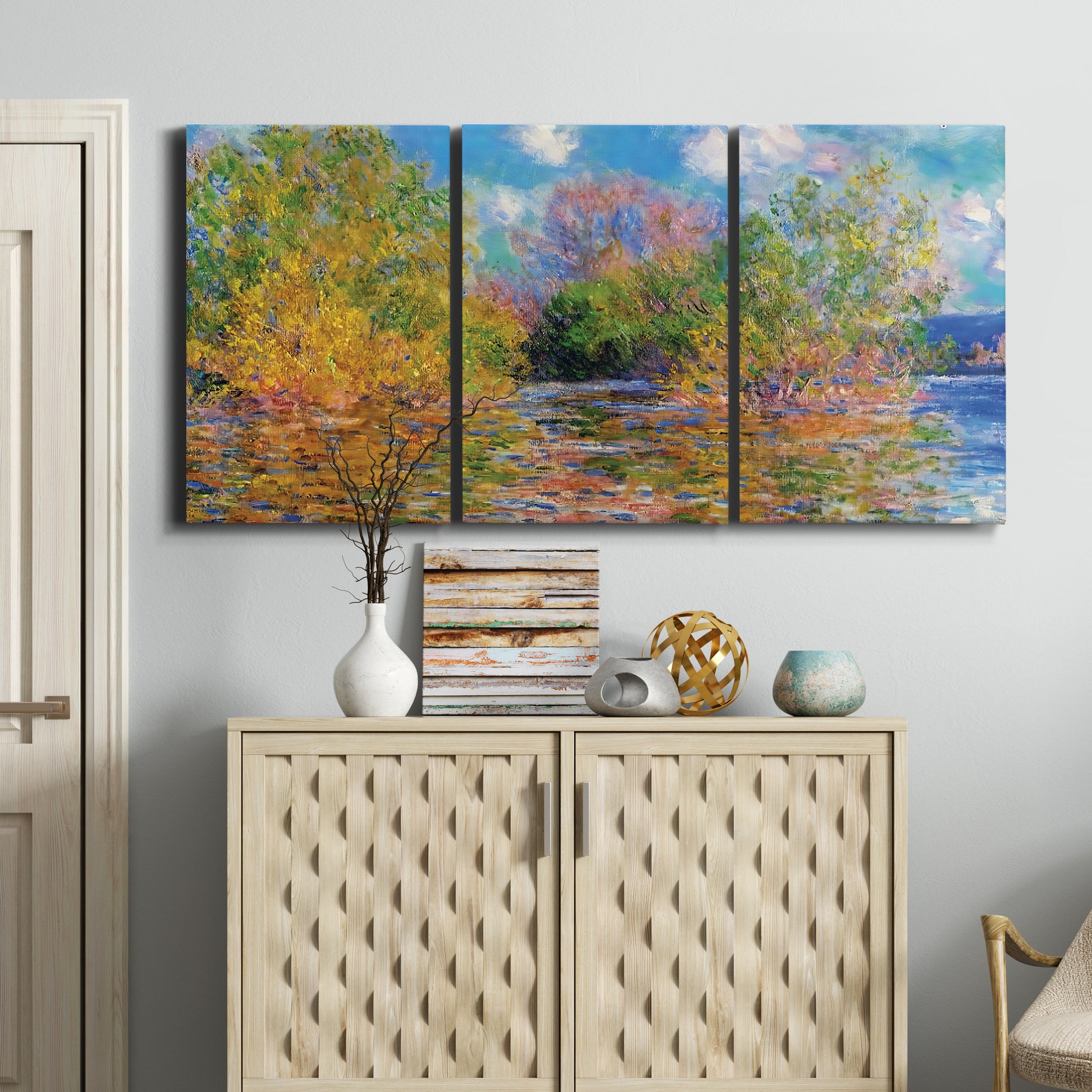 Three-panel canvas wall art featuring wide river landscape, displayed above a cabinet in an entryway.