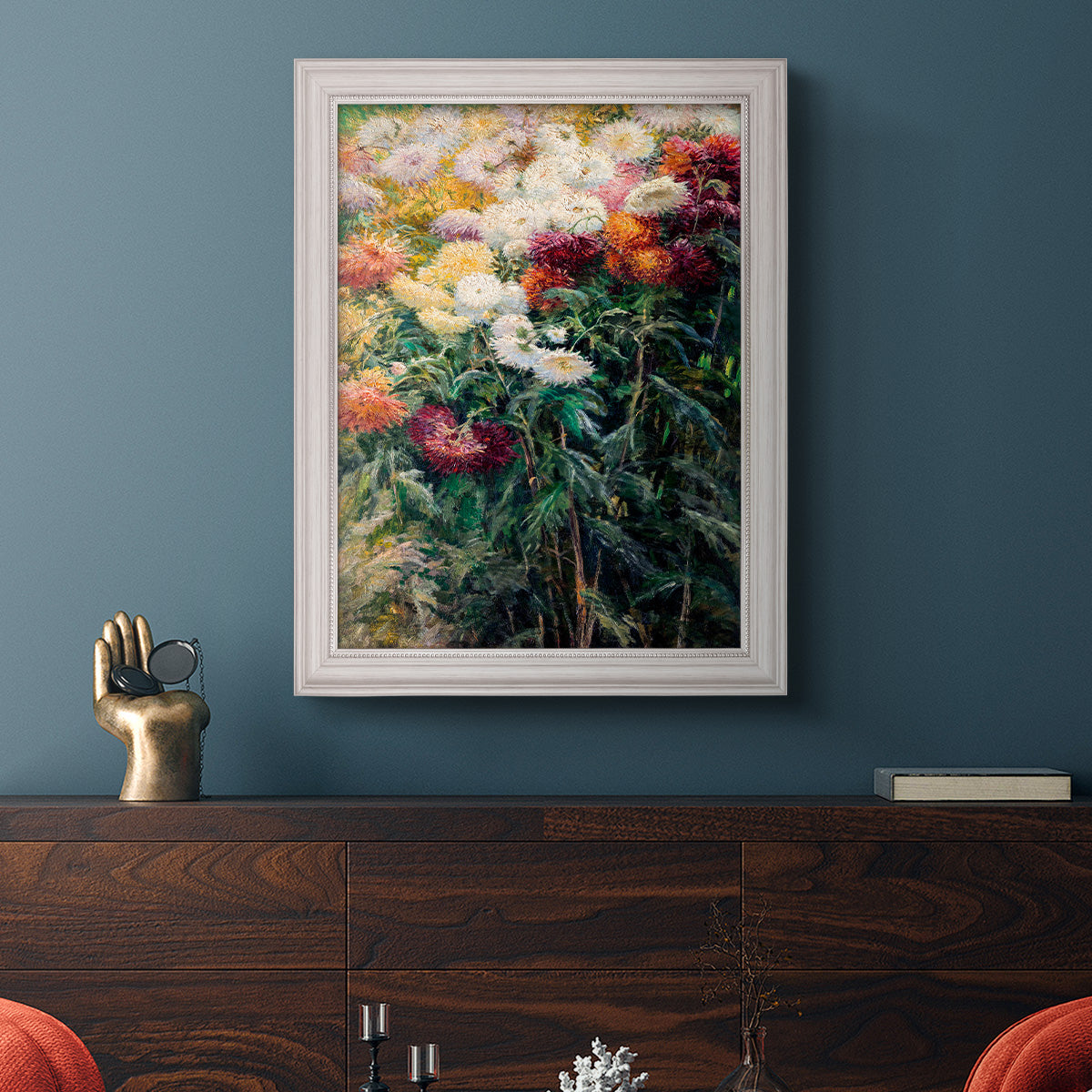 Impressionist garden floral painting by Gustave Caillebotte in an ornate weathered white frame displayed in a dark-toned interior setting.