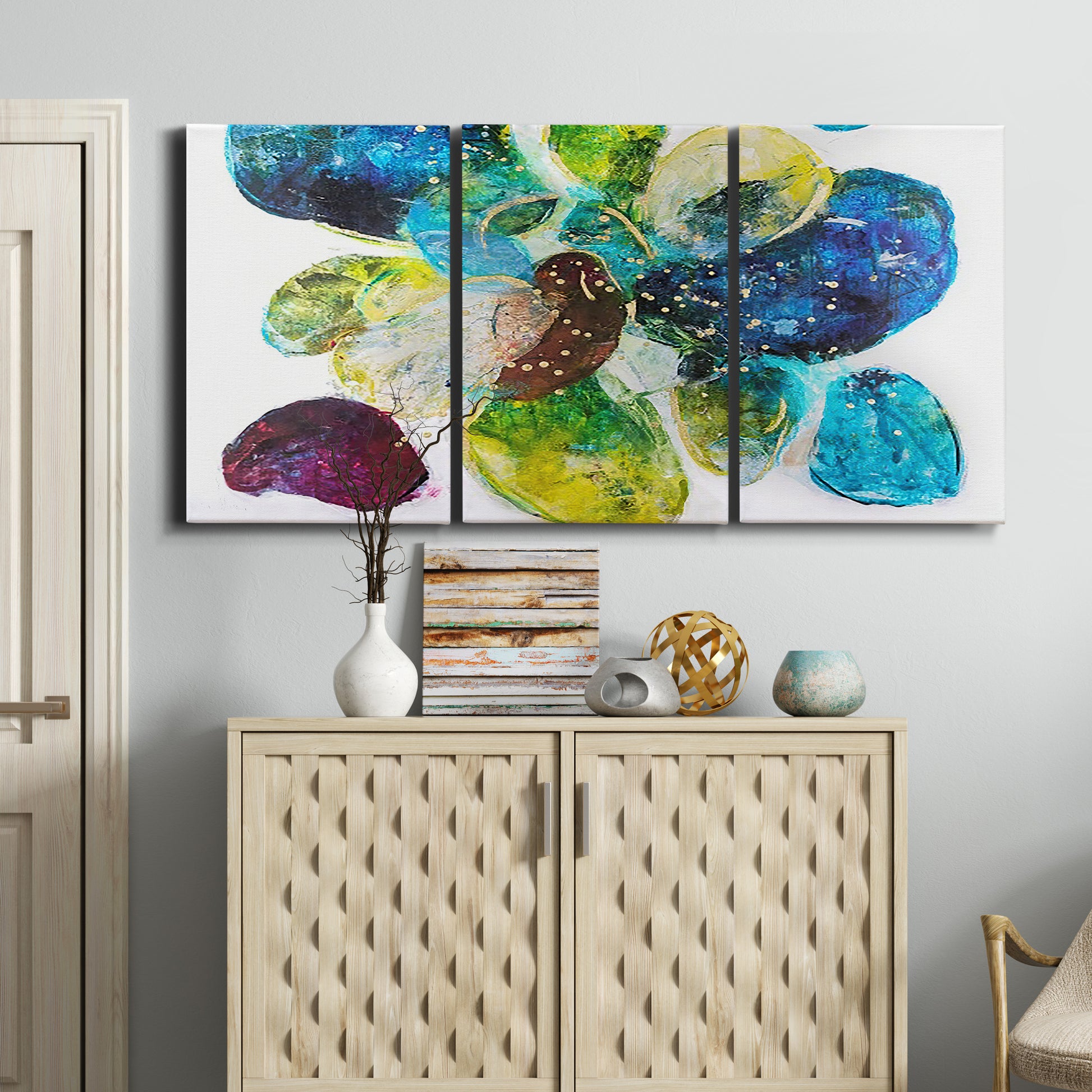 Three-panel canvas wall art featuring expressive abstract color interpretations, displayed above a cabinet in an entryway.
