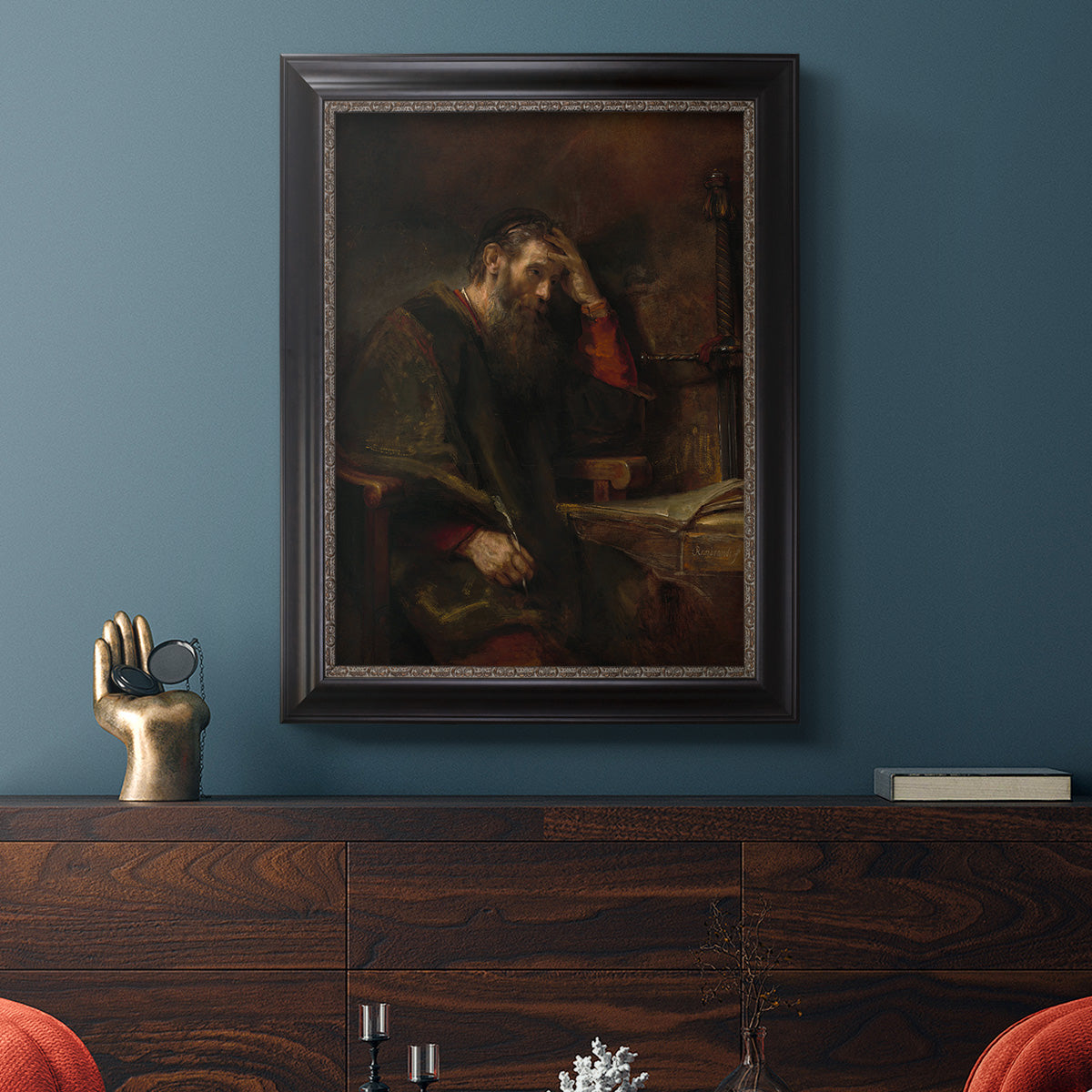 Classical religious portrait of Paul the Apostle by Rembrandt van Rijn in an ornate black frame with gilded inner detail displayed in a dark-toned interior setting.