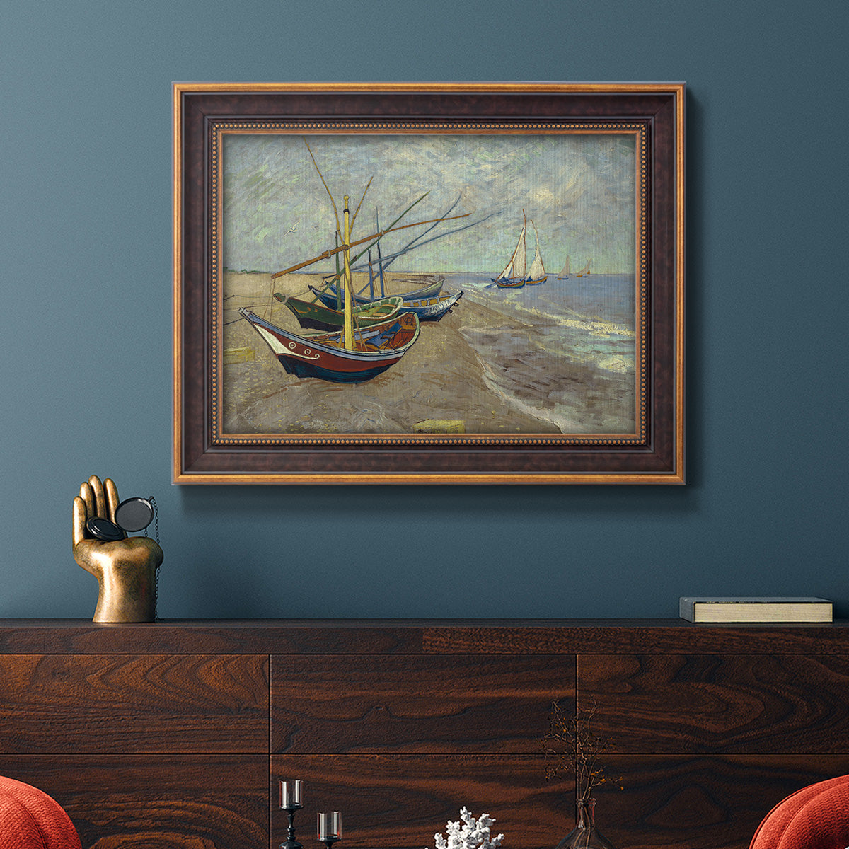 Impressionist coastal fishing boats scene by Vincent van Gogh in an ornate bronzed mahogany wood frame displayed in a dark-toned interior setting.
