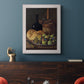 Realist still life with figs and bread by Luis Meléndez in an ornate weathered white frame displayed in a dark-toned interior setting.