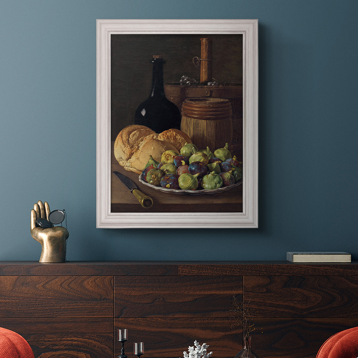 Realist still life with figs and bread by Luis Meléndez in an ornate weathered white frame displayed in a dark-toned interior setting.