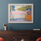 Pointillist coastal seascape by Paul Signac in an ornate weathered white frame displayed in a dark-toned interior setting.