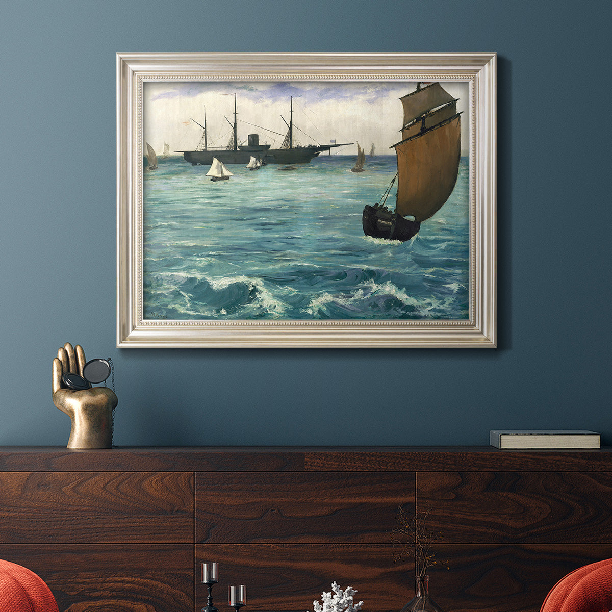 Impressionist naval seascape with the Kearsarge by Édouard Manet in an ornate champagne frame displayed in a dark-toned interior setting.