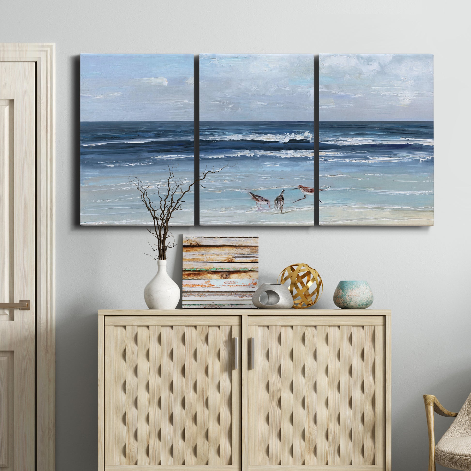 Three-panel canvas wall art featuring loose farmhouse style floral painting, displayed above a cabinet in an entryway.