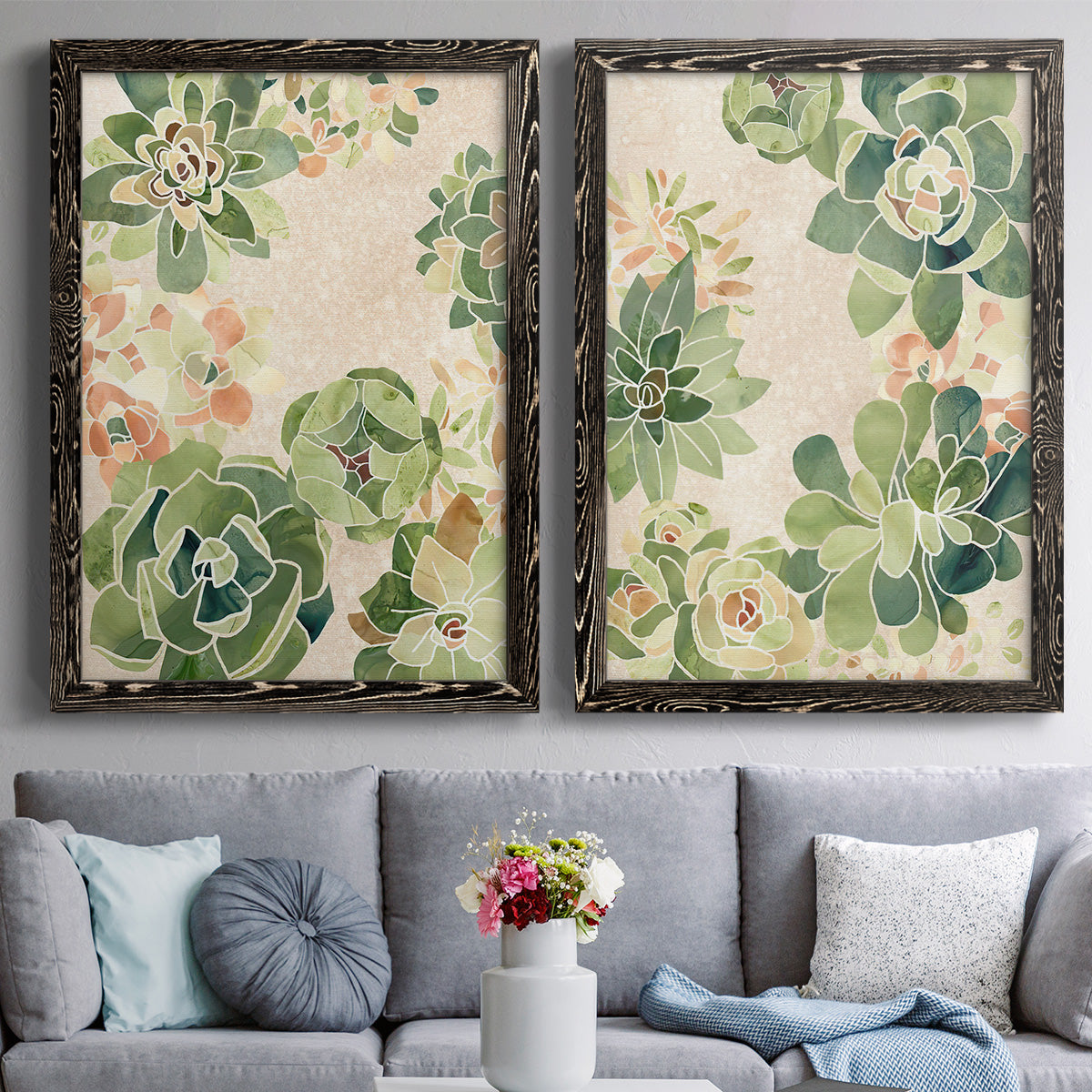 Set of two black barnwood framed canvas prints depicting paired decorative botanical pattern prints with green rosettes, peach blossoms, and mosaic-like outlines above a sofa in a contemporary living room.