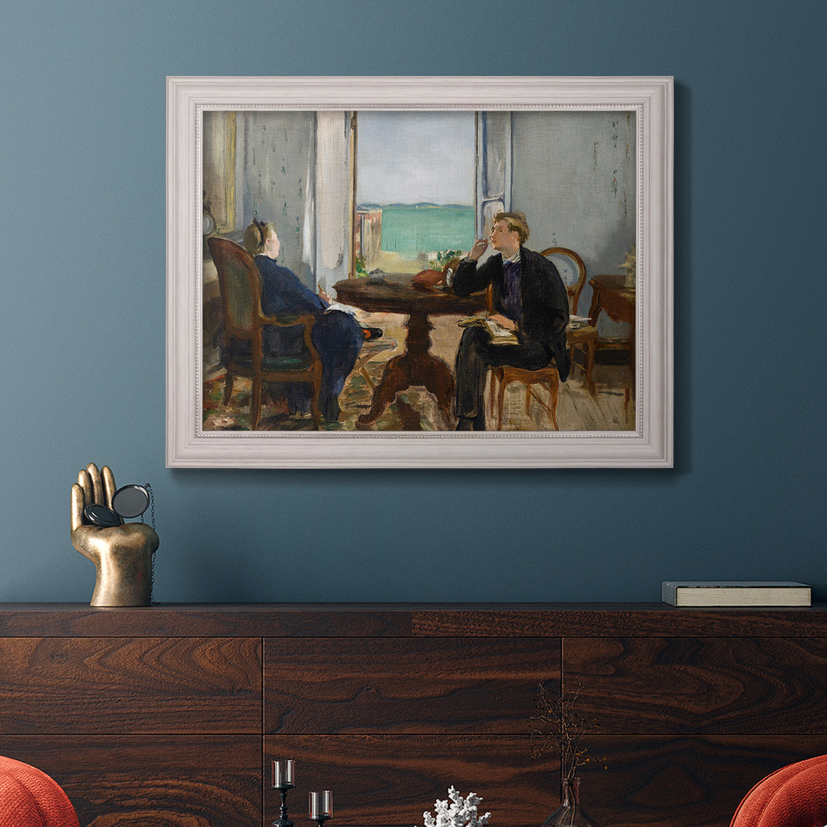 Impressionist interior scene by Édouard Manet in an ornate weathered white frame displayed in a dark-toned interior setting.